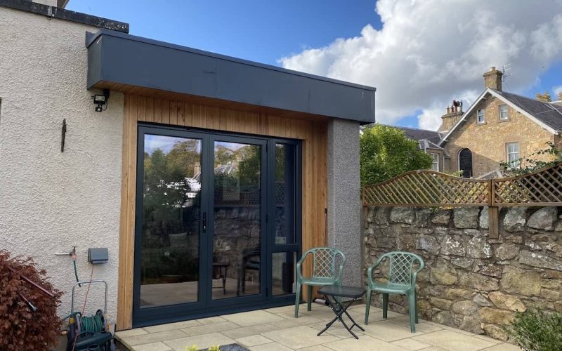 Contemporary garden room with timber cladding and large glass doors, creating a stylish outdoor living space.